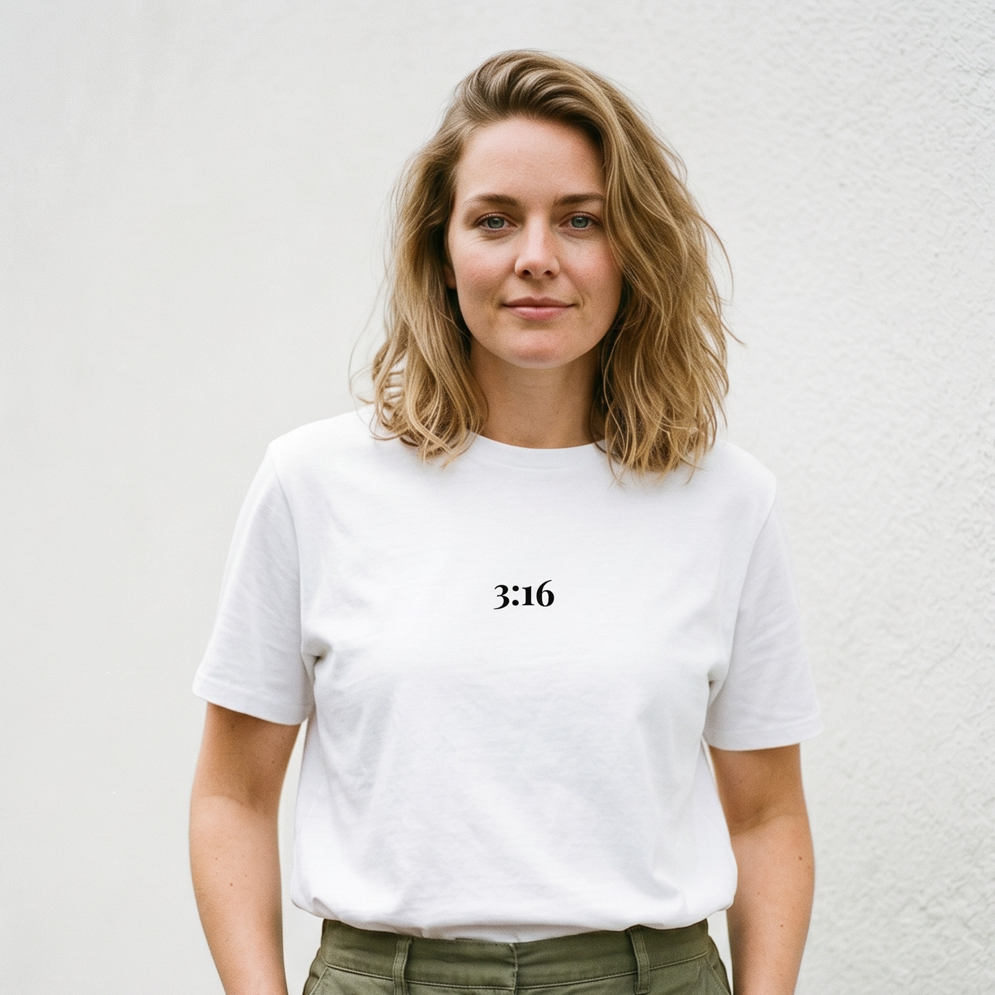 Person wearing a white t-shirt with '3:16' text against a light background