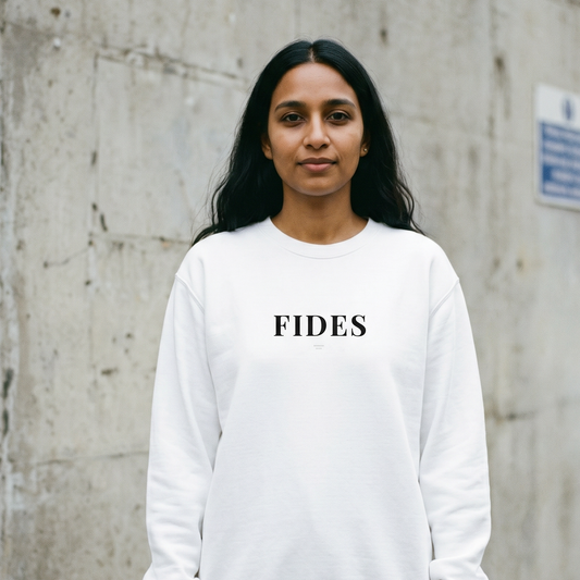 Person wearing a white sweatshirt with 'FIDES' text against a concrete wall.