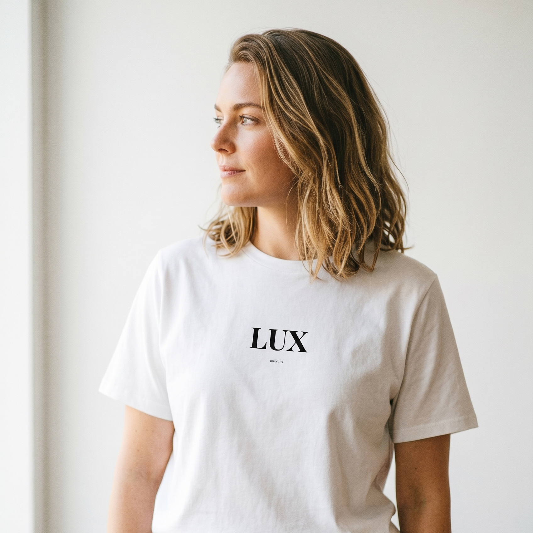 Person wearing a white t-shirt with 'LUX' printed on it against a plain background