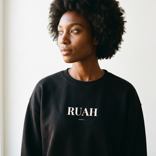 Person wearing a black sweatshirt with 'RUAH' printed on it against a white background