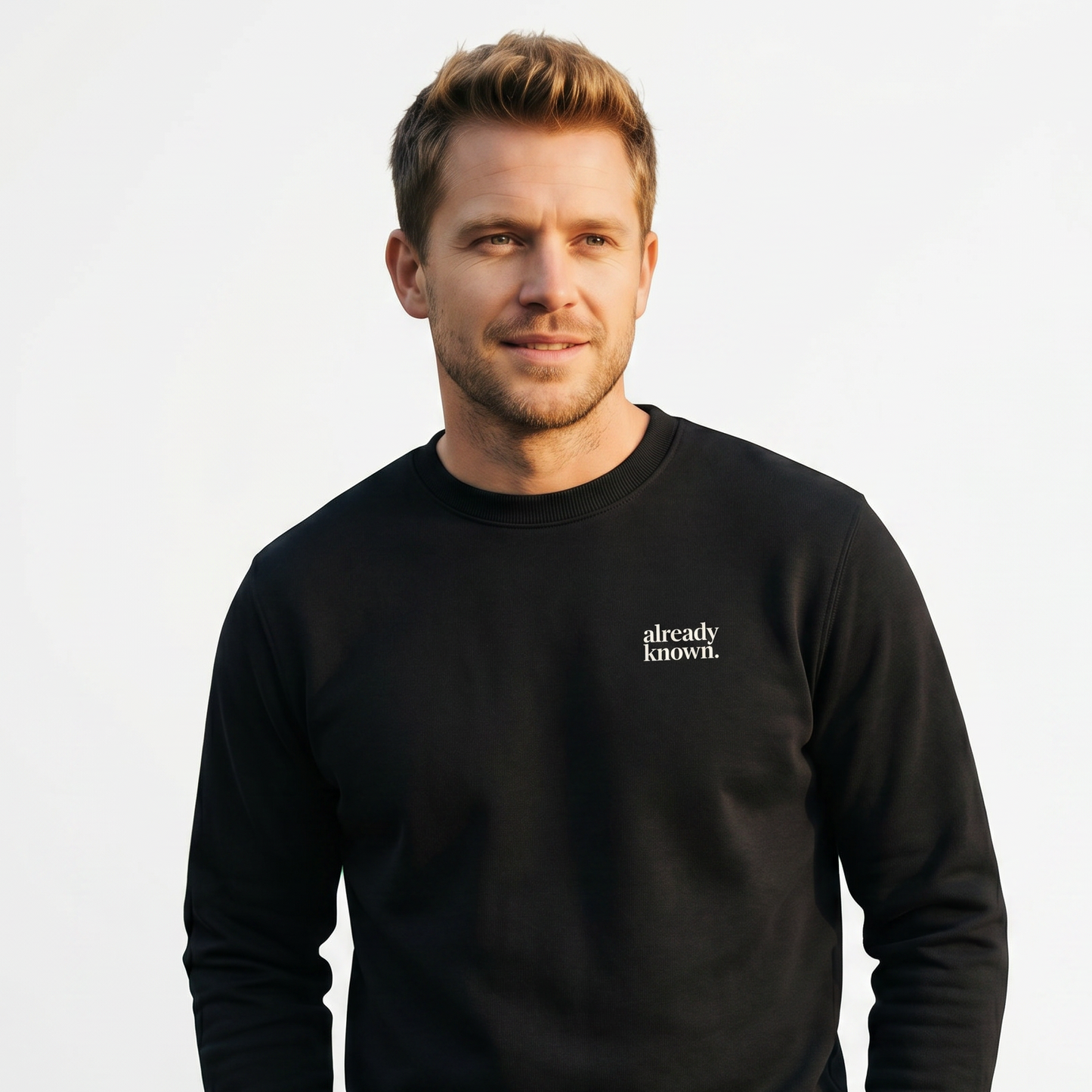 Man wearing a black sweatshirt with 'already known' text on a light gray background