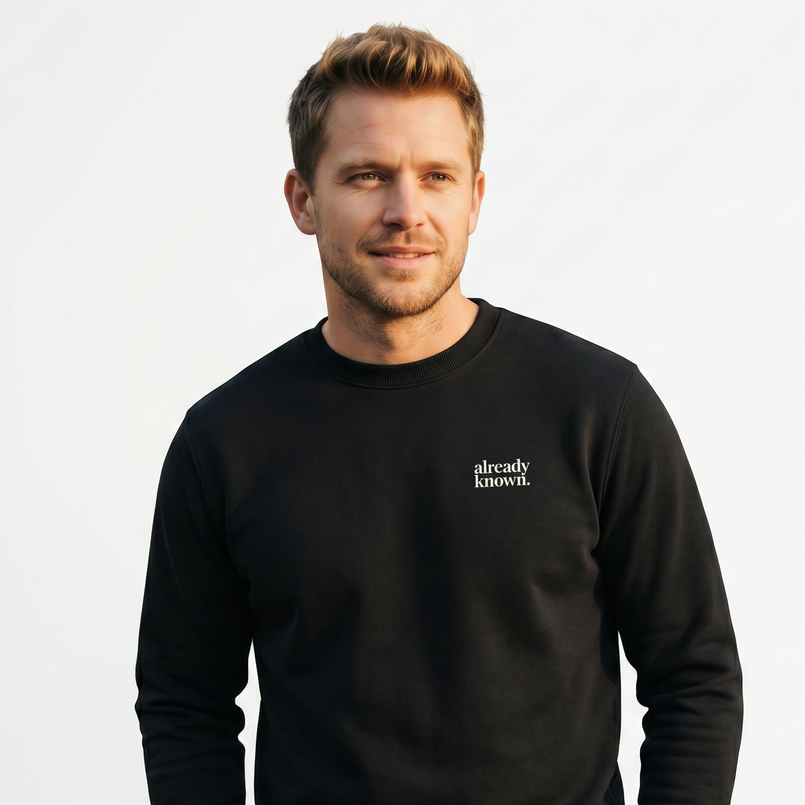 Man wearing a black sweatshirt with 'already known' text on a light gray background