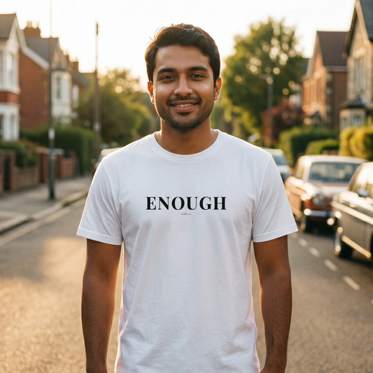 Man wearing a white t-shirt with 'ENOUGH' text on a residential street.