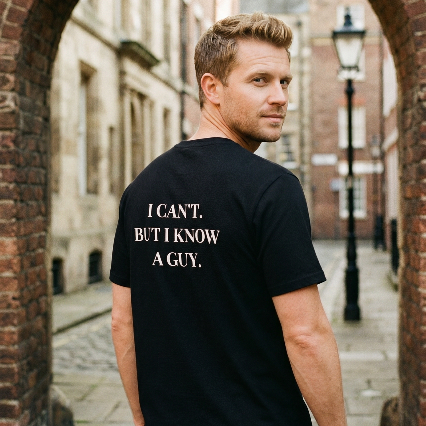 Man wearing a black t-shirt with text in an urban setting