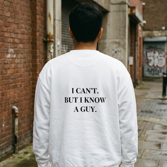 Person wearing a white sweatshirt with text on the back in an urban alleyway.